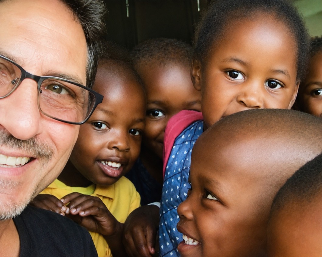 Randy Finkbeiner surrounded by laughing Zonke Izizwe children